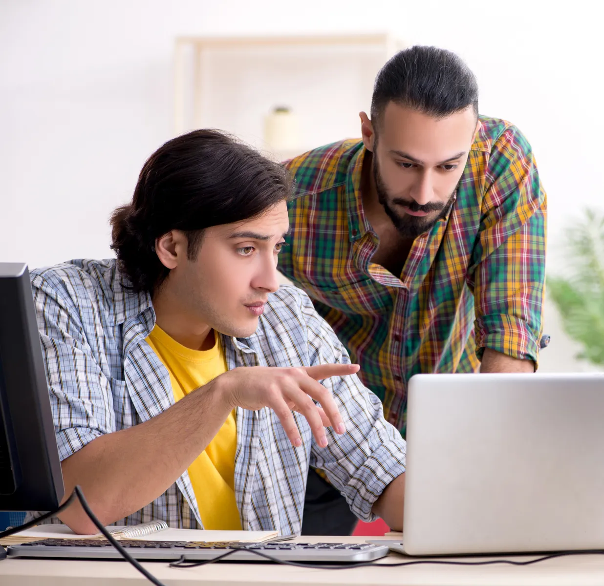 Two IT technicians troubleshooting together at a screen