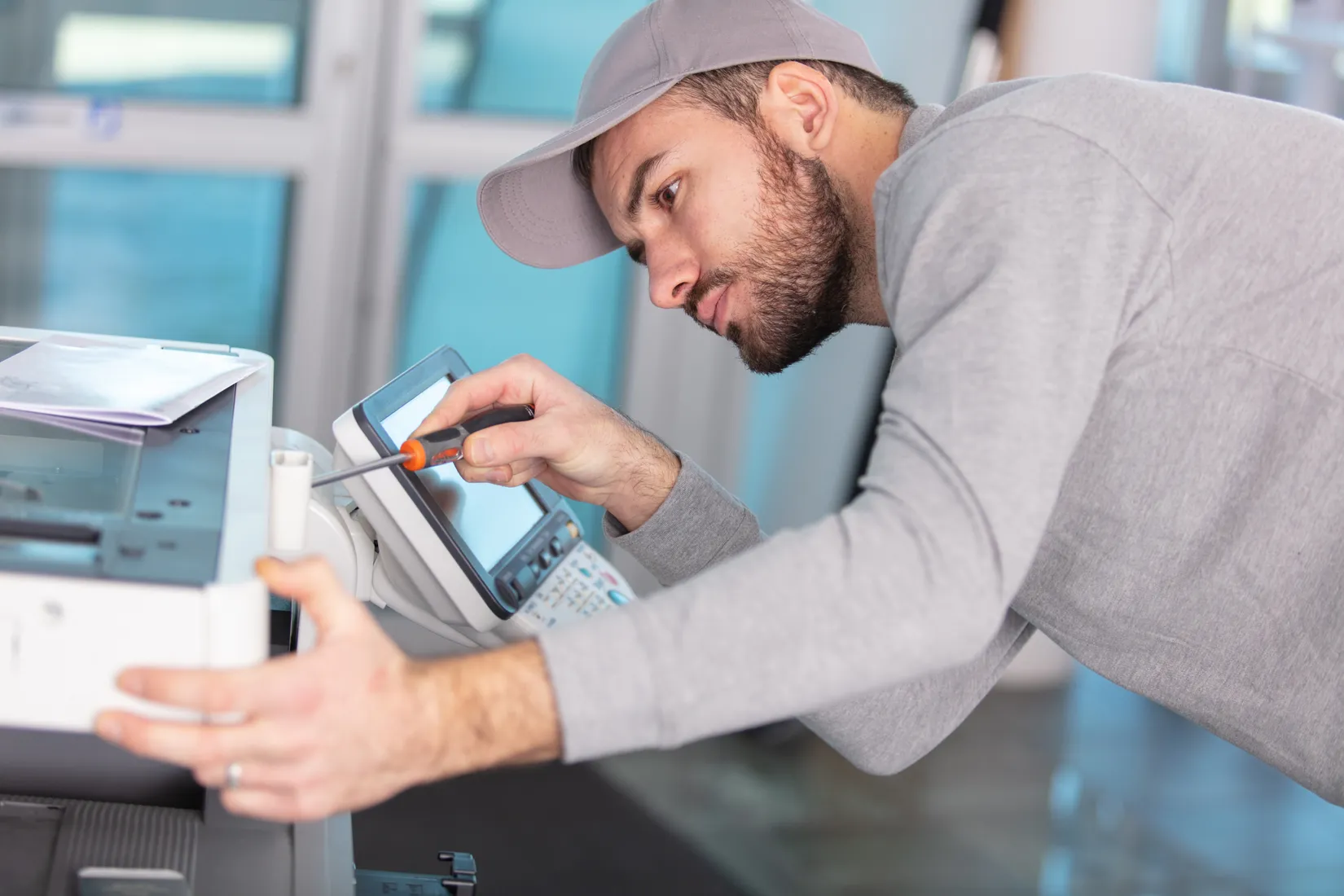 A technician servicing an office copier