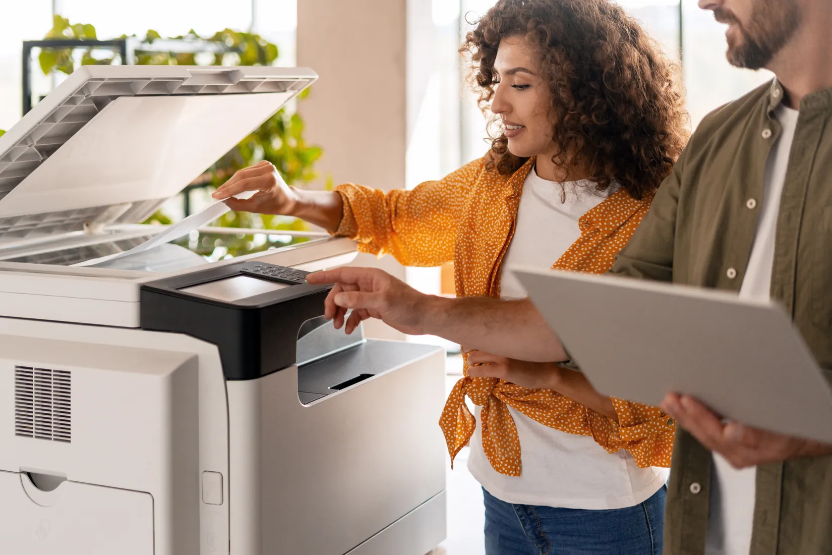 Two colleagues using a multifunction office copier