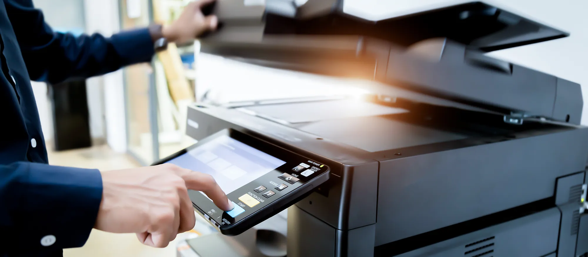 A professional operating the touchscreen of a multifunction office copier