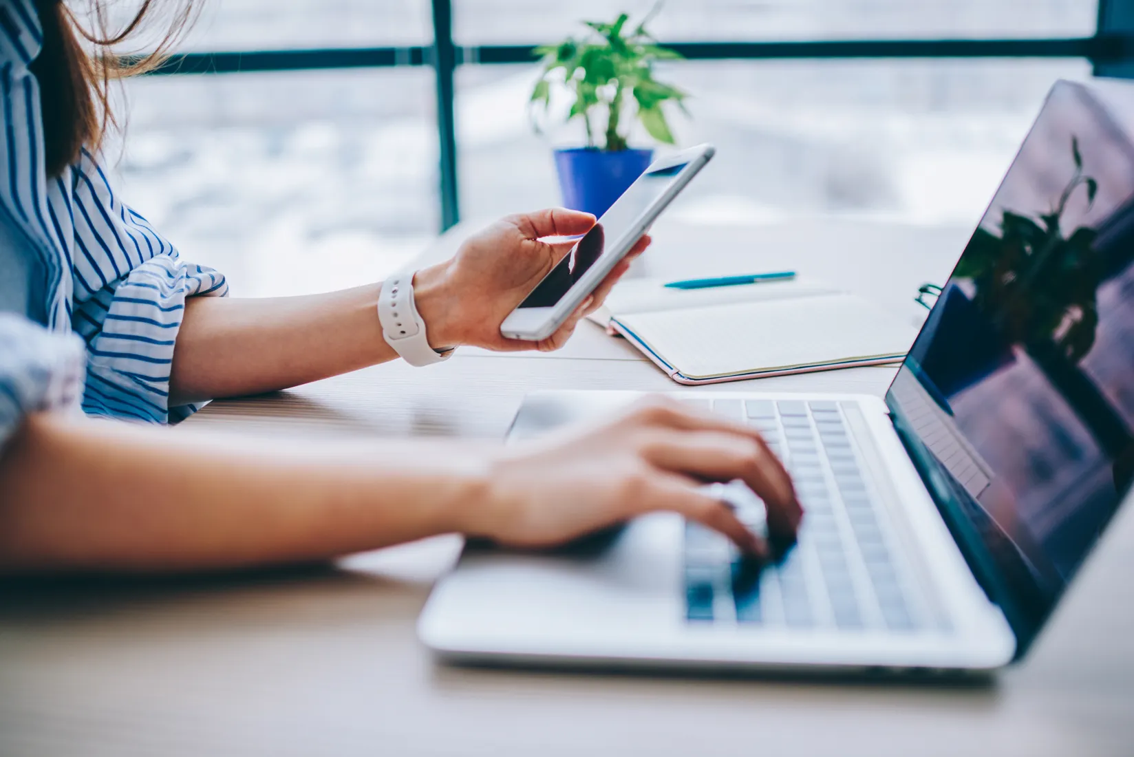 Working across a laptop and phone at a desk